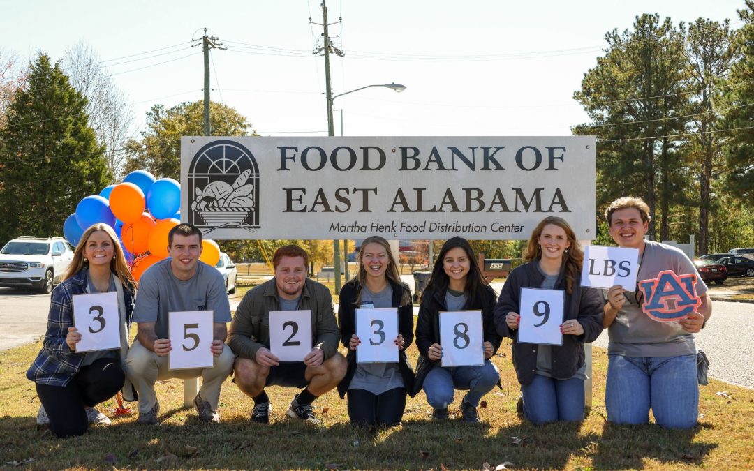 Beat Bama Food Drive students reveling their final total for the year with large signs