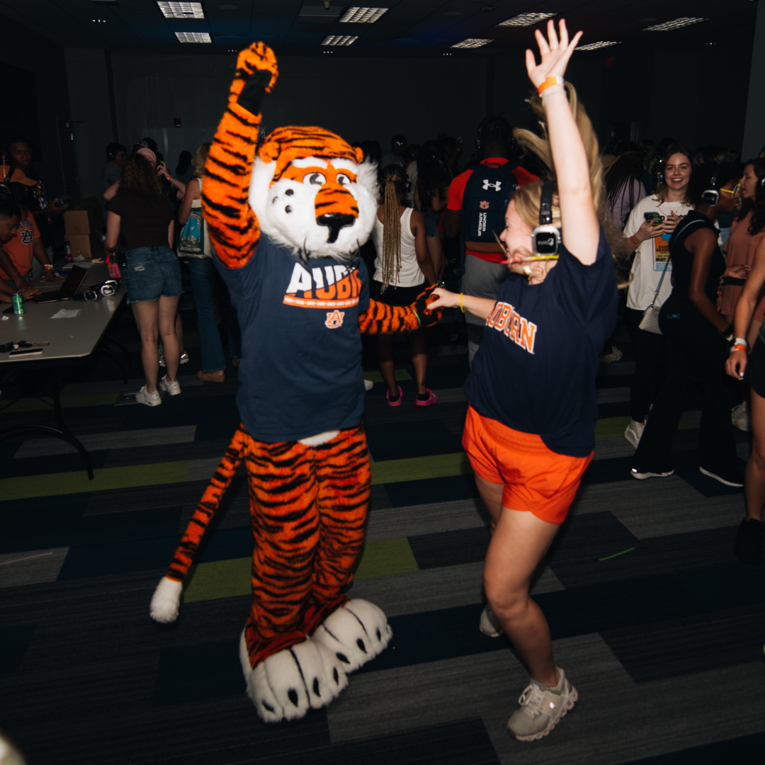 Aubie and student dancing